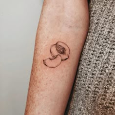 a small tattoo on the arm of a woman's left arm, with an apple in it