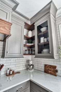 a kitchen with gray cabinets and white counter tops