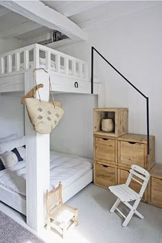 a white bunk bed sitting next to a wooden dresser