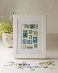 a white frame sitting on top of a table filled with stamps