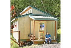 a man sitting in front of a small house