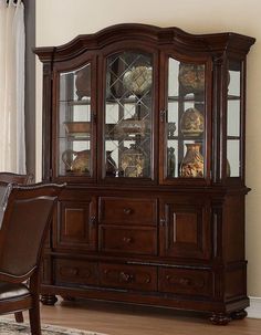 a wooden china cabinet with glass doors and drawers