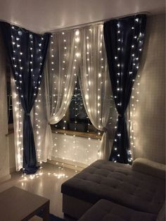 a living room filled with furniture and lights on the windows sill, curtains hanging from the ceiling