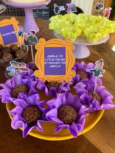 purple flowers and pineapples on a yellow plate in front of a cake stand