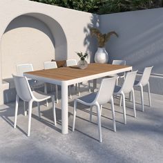 a white table and chairs in front of a wall with an arch on it's side