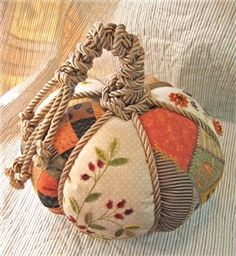 a handbag made out of fabric with flowers and leaves on the inside is sitting on a bed