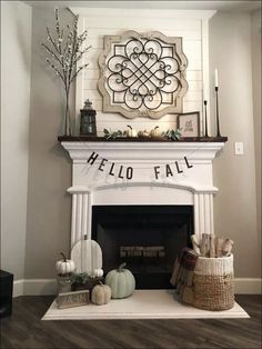 a white fireplace with a hello fall sign above it and some pumpkins on the mantle