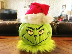 a green grin face pumpkin with a santa hat on