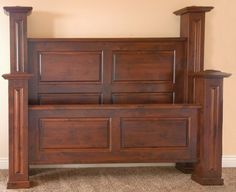 a large wooden bed frame in a room with carpeted flooring and beige walls