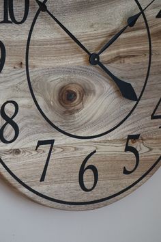 a wooden clock with black numbers on it