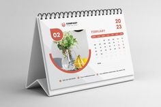 a desk calendar with a plant in a vase