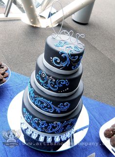 a blue and white cake sitting on top of a table next to other desserts