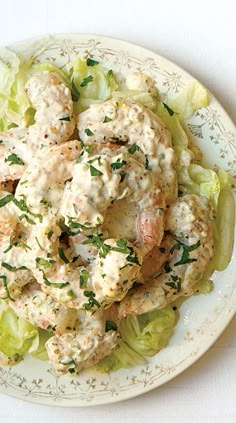 a white plate topped with chicken salad and lettuce on top of a table