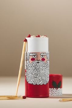 a cup with chopsticks in front of it and a santa clause mug next to it