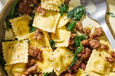 pasta with meat and spinach in a skillet next to a knife and fork