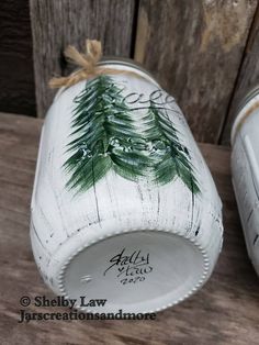 two white vases with pine trees painted on them