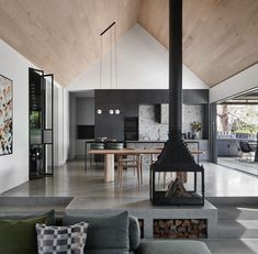 a living room filled with furniture and a fire place in front of a kitchen area