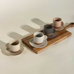 coffee cups and saucers on a wooden tray