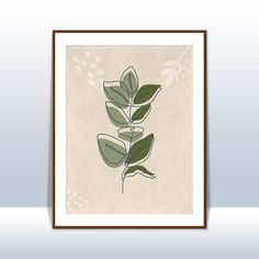 a green plant with leaves is shown in a brown frame on a white wall above it