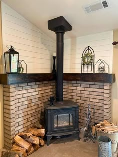 a wood burning stove sitting inside of a living room next to a pile of logs