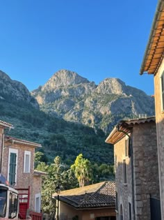 the mountains are in the distance behind some buildings