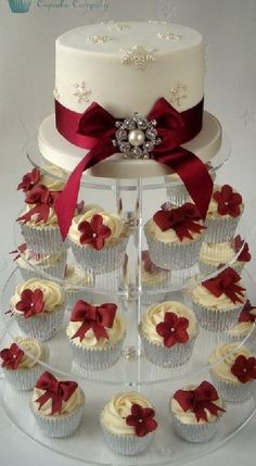 cupcakes are arranged on a clear cake stand