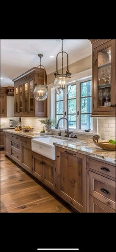 a kitchen filled with lots of wooden cabinets and counter top space next to a window