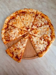 a sliced pizza sitting on top of a wooden cutting board