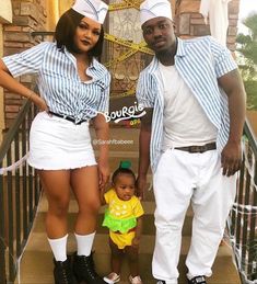 a man and woman standing on the steps with a small child in front of them