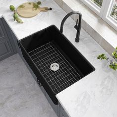 a kitchen sink sitting on top of a counter next to a cutting board and knife