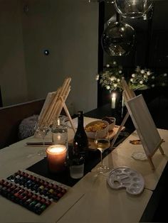 an easel is sitting on top of a table with wine glasses and other items