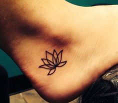 a small tattoo on the foot of a person with a lotus flower in its center