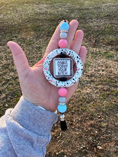 a hand holding a bracelet with a message on it