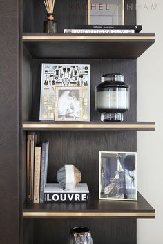 the shelves are filled with books, candles and other decorative items for display on them