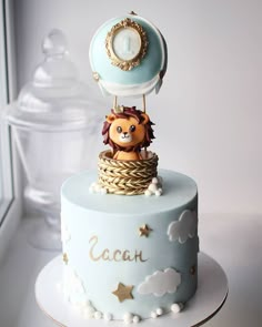 a blue and white cake with a lion on top