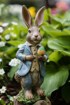 a statue of a rabbit holding an easter egg in its hand and wearing a suit