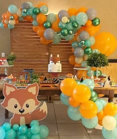 an animal themed birthday party with balloons and streamers on the floor, including a fox balloon arch