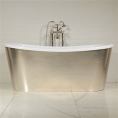 a bath tub sitting on top of a white tiled floor next to a faucet