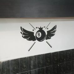 a pool ball with wings and stars on the wall