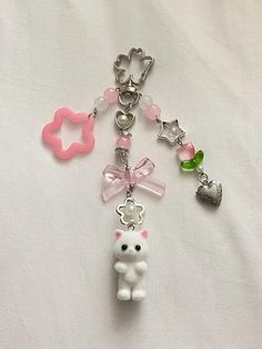 a keychain with a teddy bear charm attached to it's side on a white surface