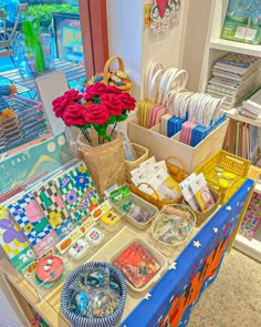 a table with many items on it in a store or office area, including flowers and cards