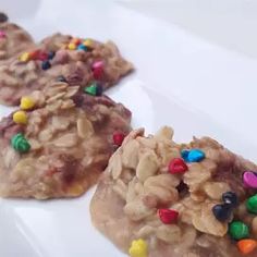 three cookies decorated with cereal and candy on a white plate