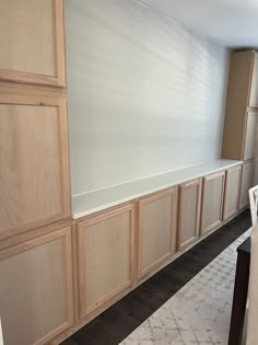 an empty room with wooden cabinets and white carpeted flooring on the side wall