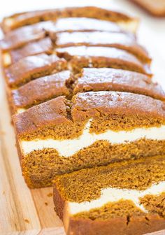 a loaf of cream cheese filled pumpkin bread on a cutting board with slices cut out