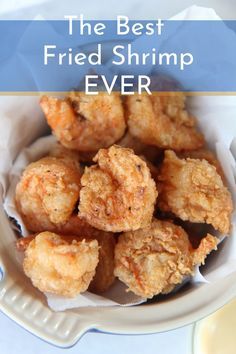 the best fried shrimp ever in a white bowl on a blue and white tablecloth