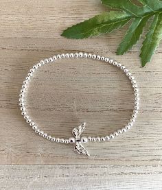 Angel Wing Silver Bead Stretch Bracelet, Silver Plated Angel Wing Bracelet, Guardian Angel-Loss of Loved One Jewellery, Friend-Mum-Sister UK This lovely bracelet would make a meaningful gift for a friend or family member as a 'thinking of you' gift to let them know they are in your thoughts. This gorgeous silver plated bead bracelet is fashioned with an intricate silver plated (lead and nickel free) angel wing.  The silver beads have been carefully threaded onto a sturdy long-lasting stretch ela Angel Wing Bracelet, Free Angel, Angel Bracelet, Silver Bead, Guardian Angel, Beaded Stretch Bracelet, Bracelet Silver, Jump Rings, Stretch Bracelet