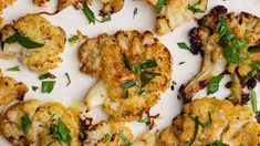 cooked cauliflower on a white plate topped with parmesan cheese and herbs