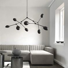 a modern living room with white walls and black accents on the ceiling, along with an l - shaped sofa