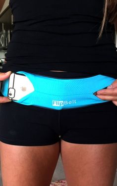 a woman in black shorts holding onto a blue belt that says flipbet on it