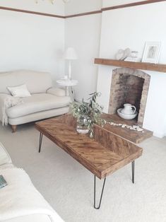 a living room with a couch, coffee table and fire place in the center area